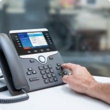 A person is using the phone on a desk.