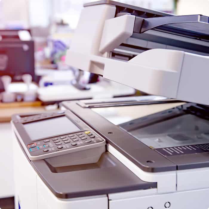 A printer with two keyboards on top of it.