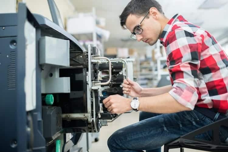 A man working on an industrial machine in a factory.