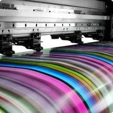 A printer is printing out colorful papers on the floor.