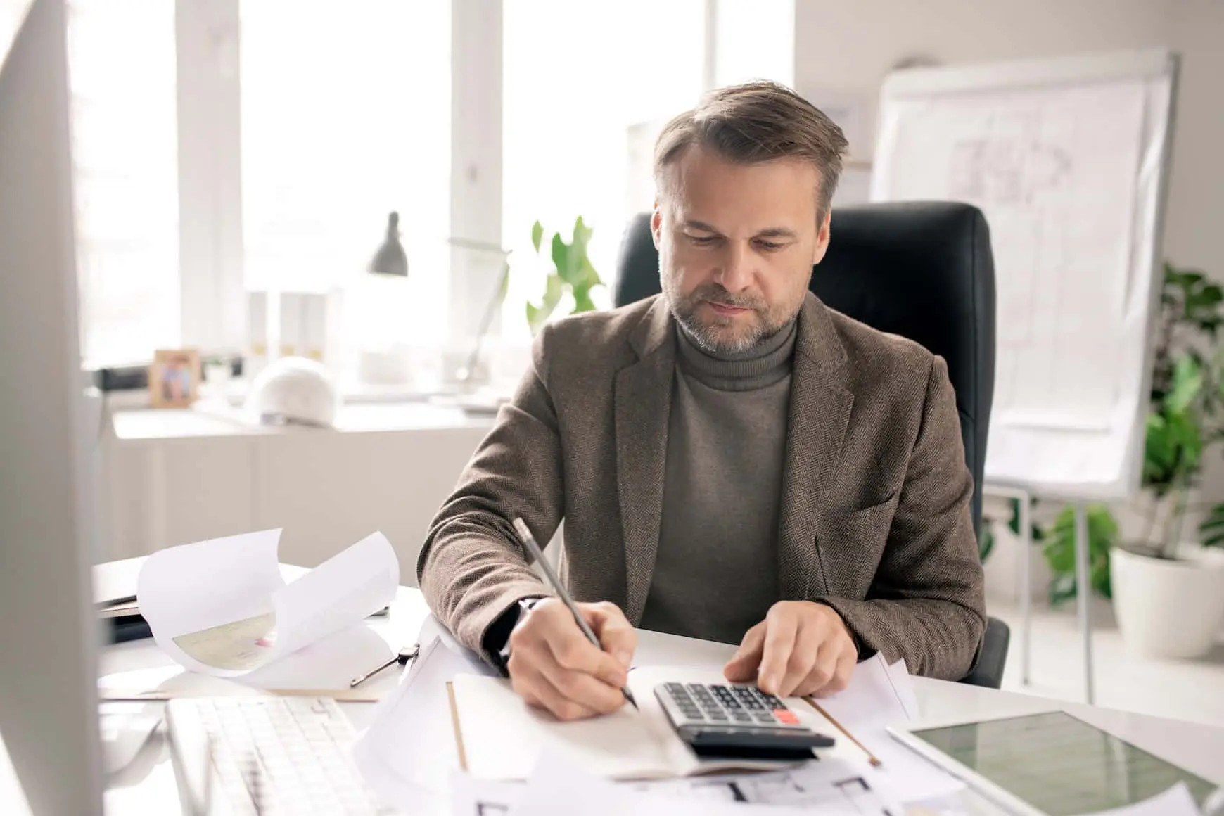 A man sitting at his desk writing on some papers